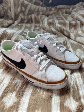 Nike White Low-Top Sneakers with Black Swoosh and Brown Trim Accent
